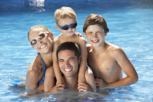 Family Having Fun In Swimming Pool